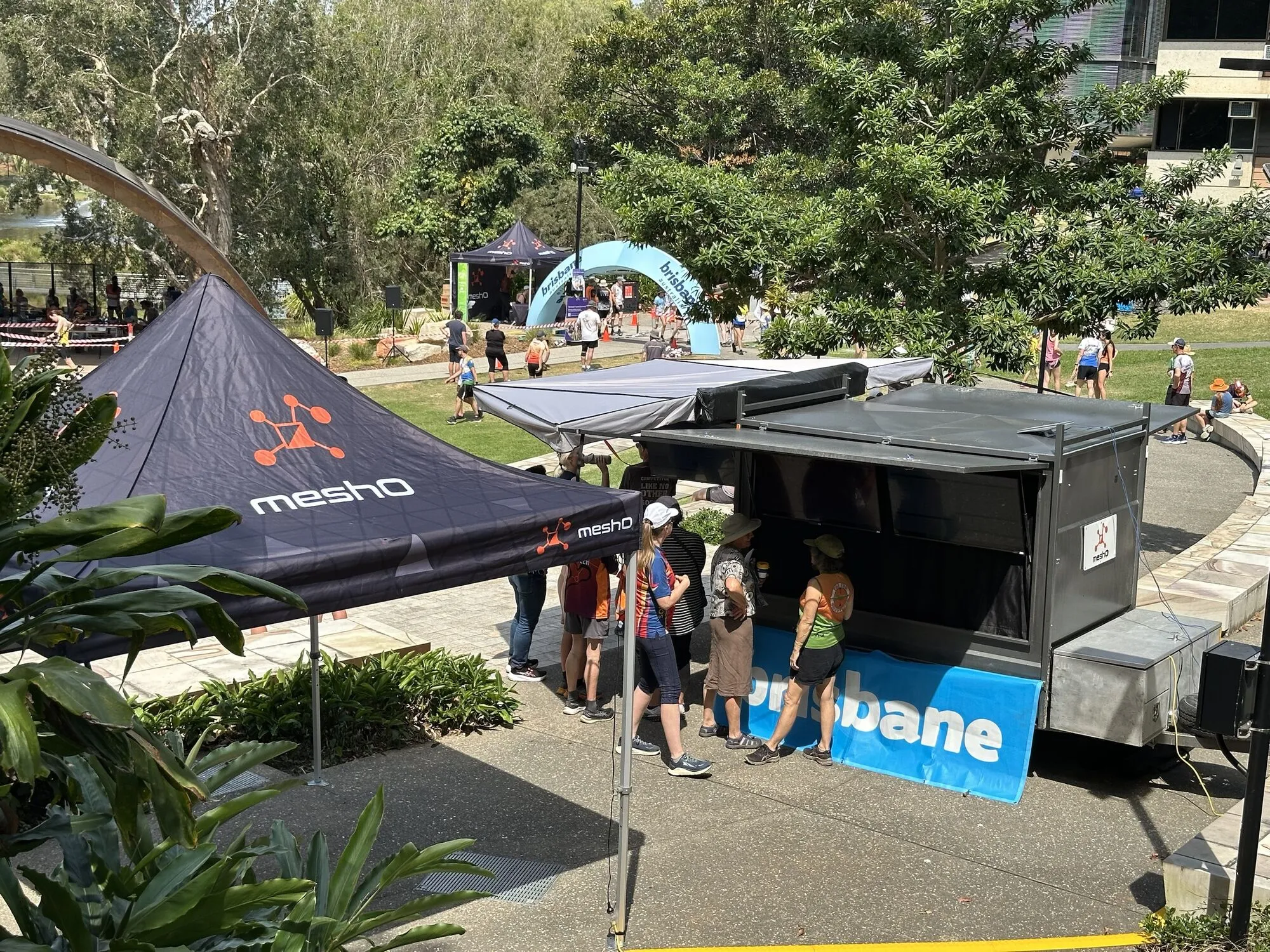 The meshO results trailer and marquees in a sprint arena, with competitors at the screens